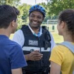 Policier municipal en train de discuter avec des jeunes dans un parc