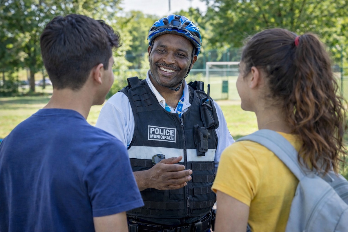 Policier municipal en train de discuter avec des jeunes dans un parc
